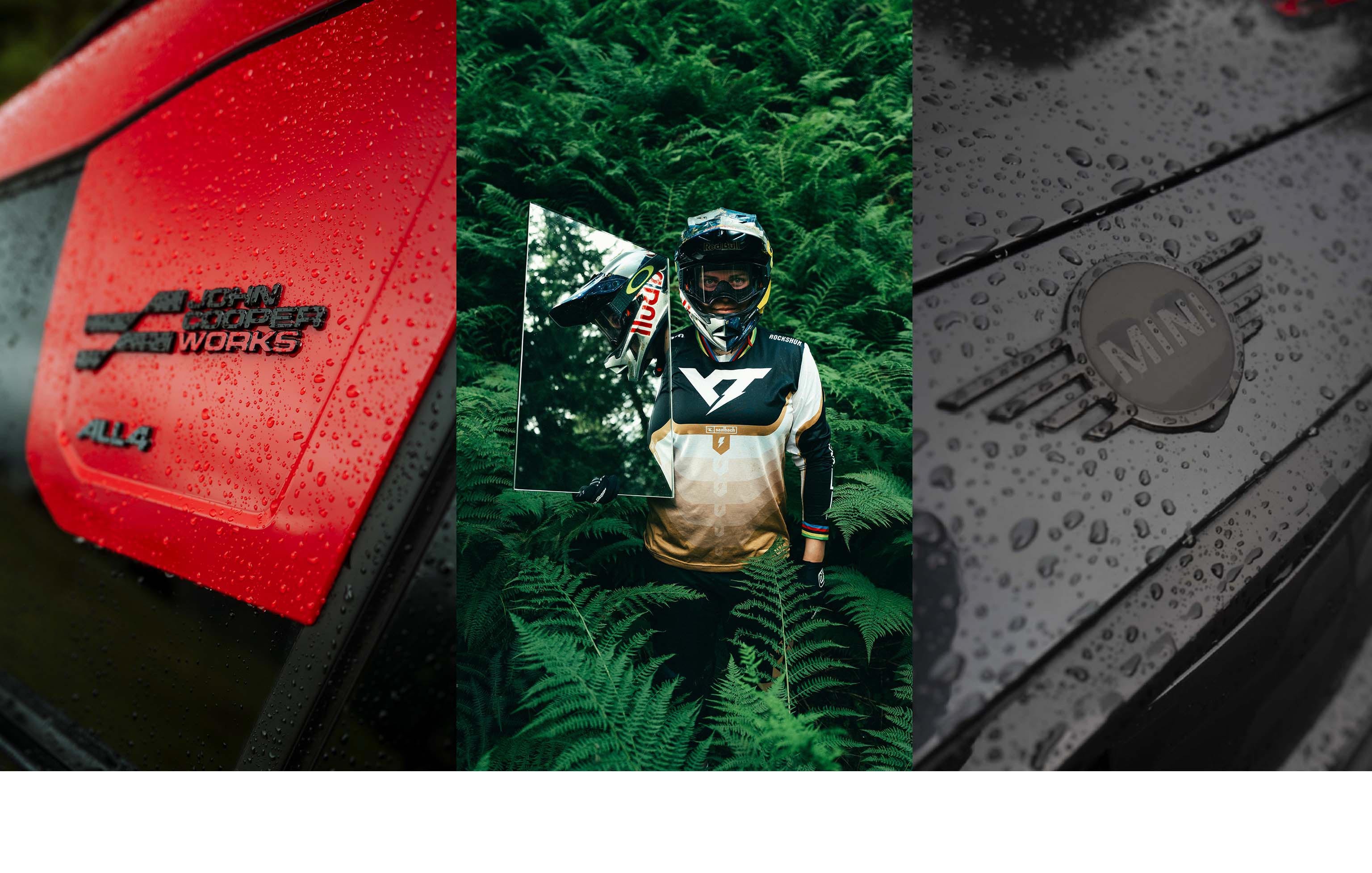 First picture: Close up of the red and black John Cooper Works ALL4 badge on the new MINI John Cooper Works Countryman. Second picture: In personalised gear and heavy-duty helmet, we see Vali’s upper half as she stands holding up a poster of herself and surrounded by thick green foliage. Third picture: Close up of water droplets on the black MINI badge on the black car bonnet.